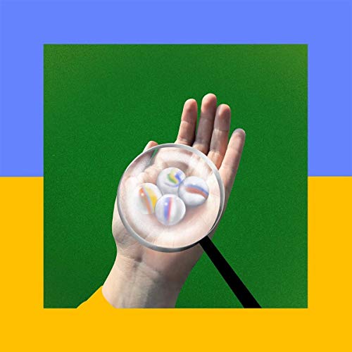 Album cover: hand holding marbles with a magnifying glass.
