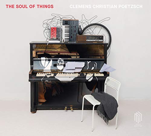 CD cover featuring a piano with scattered objects and paper airplanes.