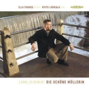 "CD cover with a man sitting by a waterfall, wearing dark clothing."