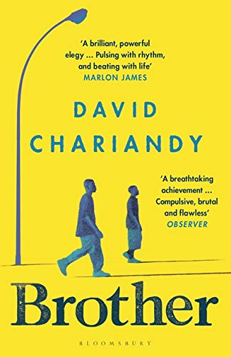 The image depicts the cover of the book "Brother" by David Chariandy. The alt text is: "Yellow book cover with blue silhouettes of two men walking under a streetlight."
