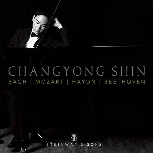 Pianist Changyong Shin in formal wear at a Steinway piano.