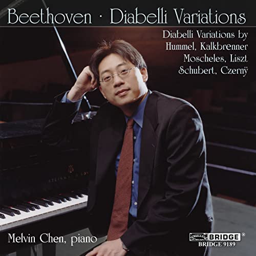 Pianist Melvin Chen in suit and glasses, beside a grand piano.