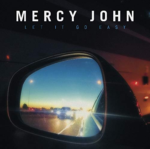 The image depicts a car's side-view mirror reflecting a highway scene with the sun setting in the background. The alt text for this image could be: "Album cover featuring a car's side-view mirror reflecting a highway at sunset."
