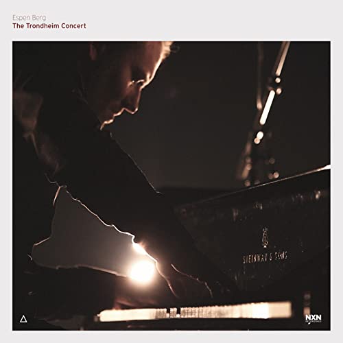 Pianist Espen Berg performing at a concert, dark and moody lighting.