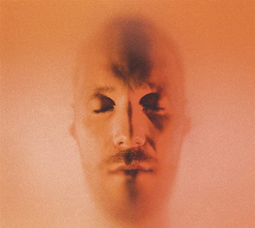 Blurred portrait of a man with a mustache on an orange background.