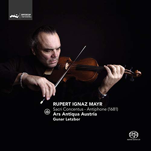 A man plays a violin on a black background with white text.