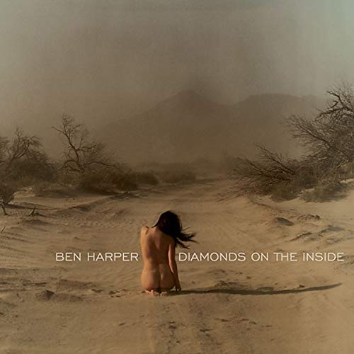 Back of a person in a desert landscape, album title text visible.