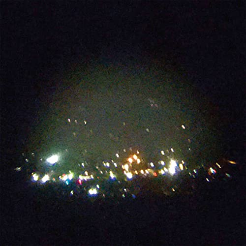 Dark, blurred image of colorful lights resembling a city skyline.
