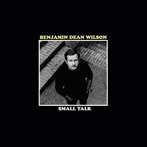 Black vinyl record cover with a black-and-white photo of a man on a sidewalk.