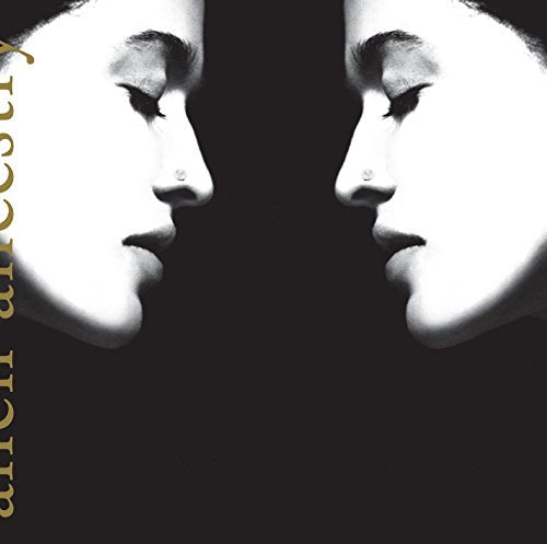 "Album cover featuring a black-and-white image of two mirrored faces against a black background."