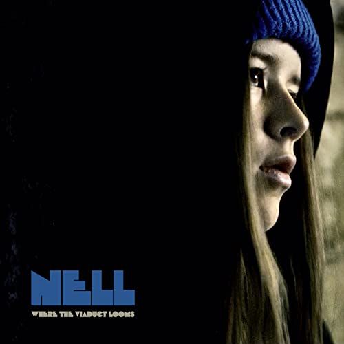 Close-up of a woman in a blue knit hat, album cover art.