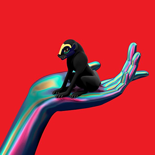 A black monkey sits on a shiny, rainbow-colored hand against a red background.