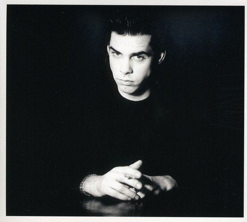 Black and white portrait of a man with dark hair against a dark background.