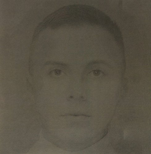 A sepia-toned, close-up portrait of a young person with short hair facing forward.