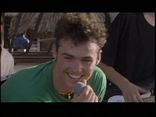 CD cover featuring a smiling man with short, curly hair holding a microphone.