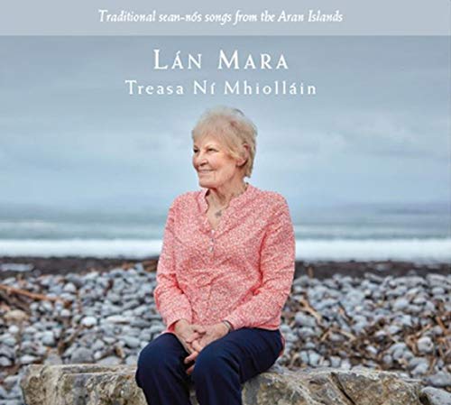"CD cover featuring an older woman sitting on a rocky beach."