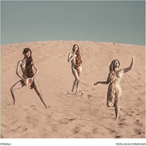 Three nude women standing on a sandy dune, posing with flowing hair.