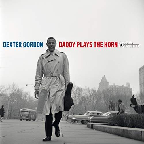 Dexter Gordon in a trench coat walking on a city street.