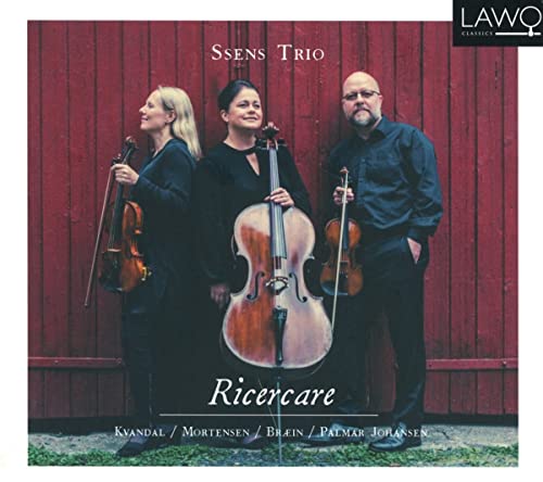 Three musicians with violin and cello stand before a red barn.