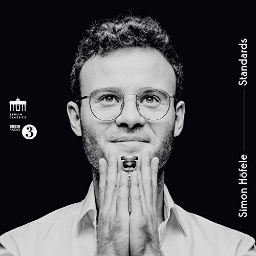 "CD cover featuring a man holding a harmonica, black background, white text."