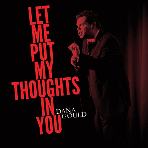 "CD cover featuring Dana Gould on stage, holding a microphone, with red text."