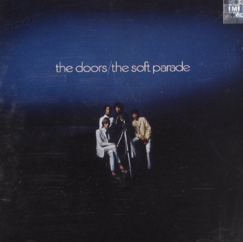 "The Doors" album cover with four band members posing around a camera on a tripod.