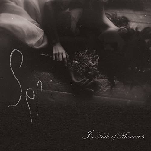 Dark album cover featuring a person lying amongst flowers and script text.
