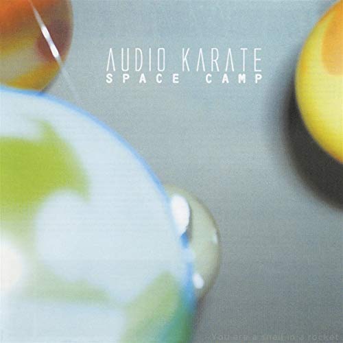 "Vinyl record cover with 'Audio Karate Space Camp' text and blurred planetary images."