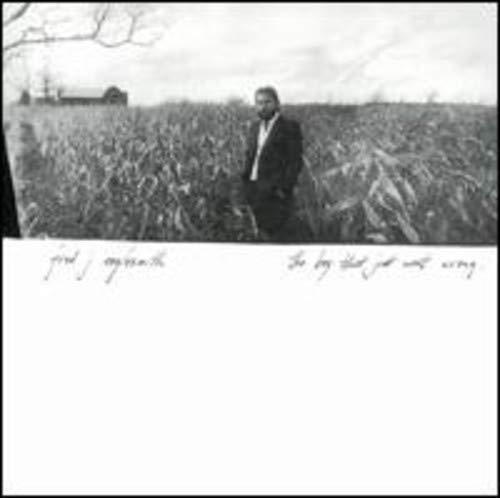 "Album cover: man in suit standing in a field, black and white image."