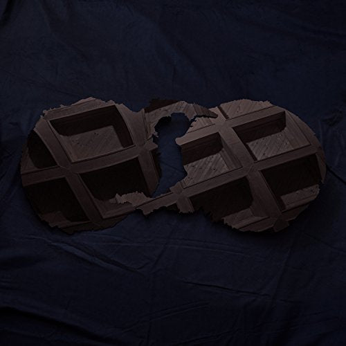 The alt text for the image is: "Torn CD case on a dark blue fabric background."