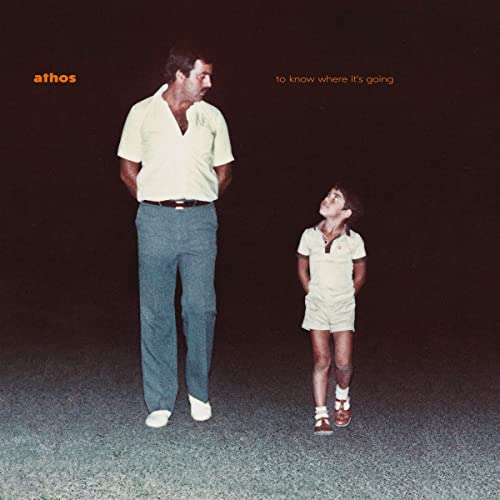 Album cover: man and child standing on dark asphalt surface.