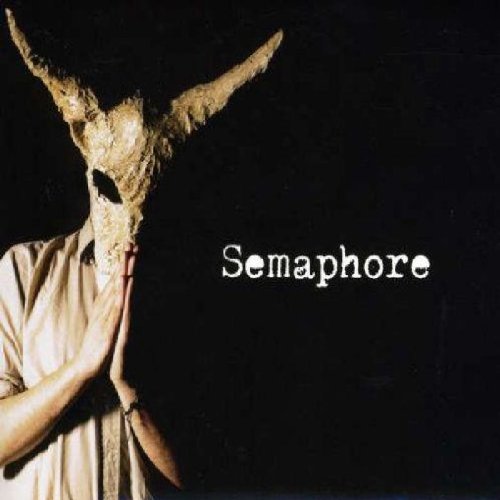 "Album cover with a person wearing a horned mask against a black background."