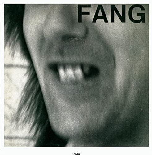 Black and white close-up of a person’s mouth with visible teeth.