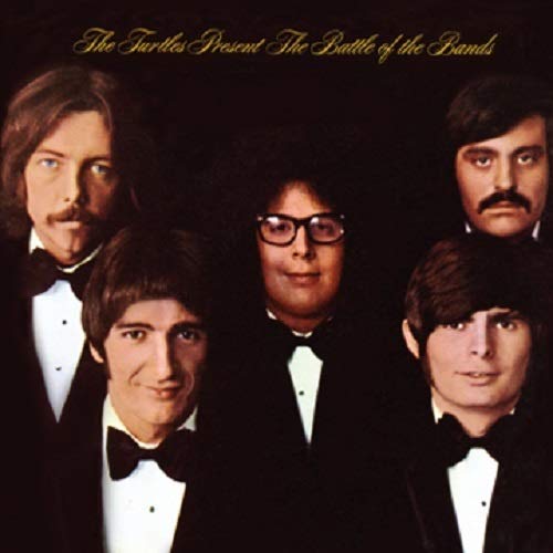"Album cover featuring five men in tuxedos against a dark background."
