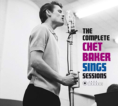 Black and white photo of Chet Baker singing into a vintage microphone.