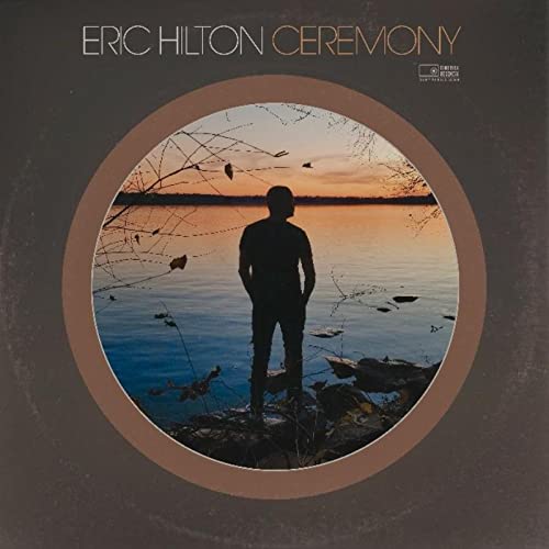 LP cover: Silhouette of a person by water under a sunset.