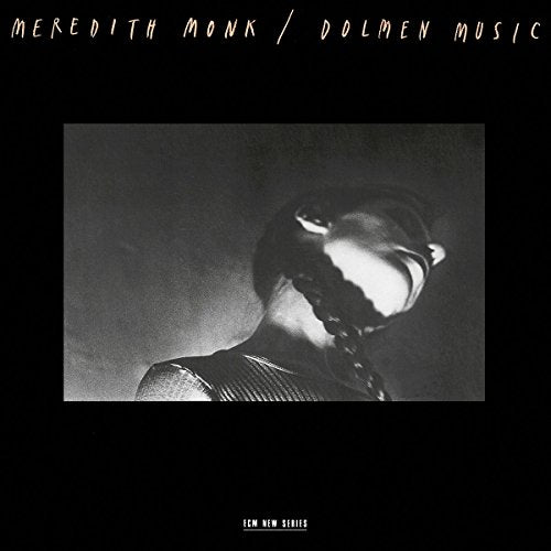 "Album cover with black background, featuring a black and white photo of a person's head."