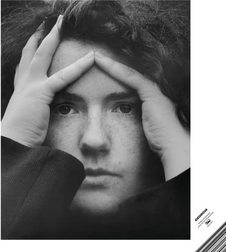 Black and white portrait of a person with hands framing their face.