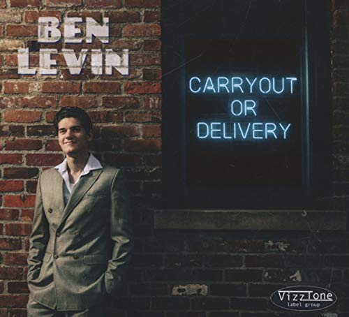 "Album cover with man in suit standing by brick wall and neon sign."