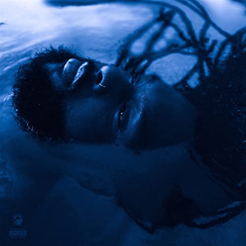 Close-up of a man’s face partially submerged in blue water.