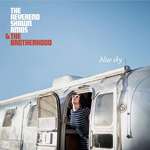 A vinyl record cover featuring a woman in a camper against a blue sky.