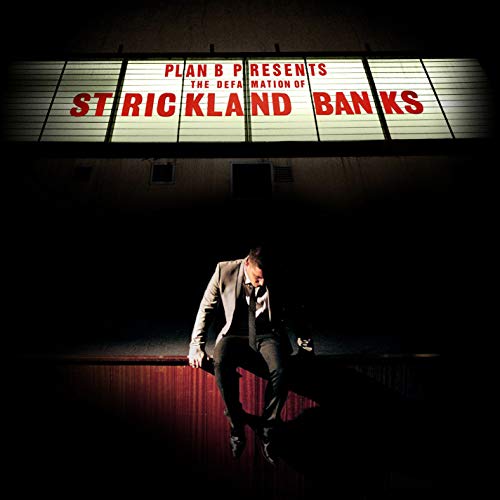 A man in a suit sits beneath a glowing sign reading Plan B Strickland Banks.