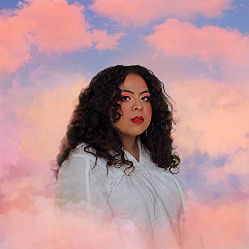 Woman with curly hair and colorful makeup against a cloudy sky.