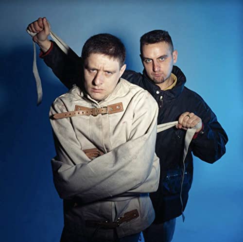 Two men, one in a straitjacket and one in a black jacket.