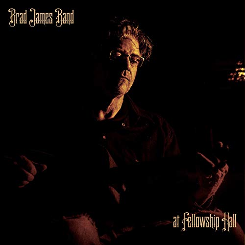 Dark album cover featuring a man with glasses playing guitar.