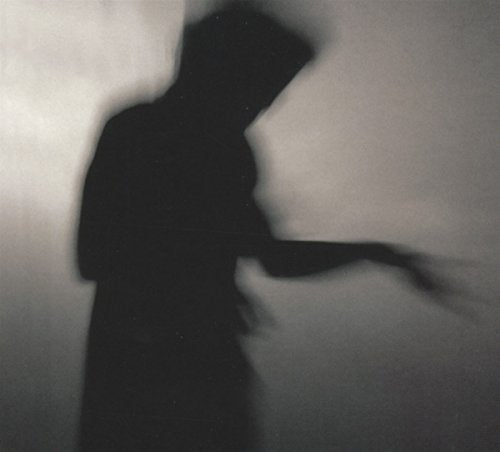 Blurry black and white silhouette of a person against a light gray background.