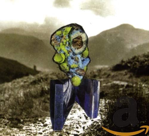 Abstract sculpture in blue and yellow, with mountains in the background.