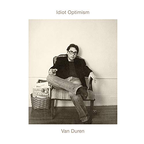 Black and white vinyl record cover with a man sitting in a striped armchair.