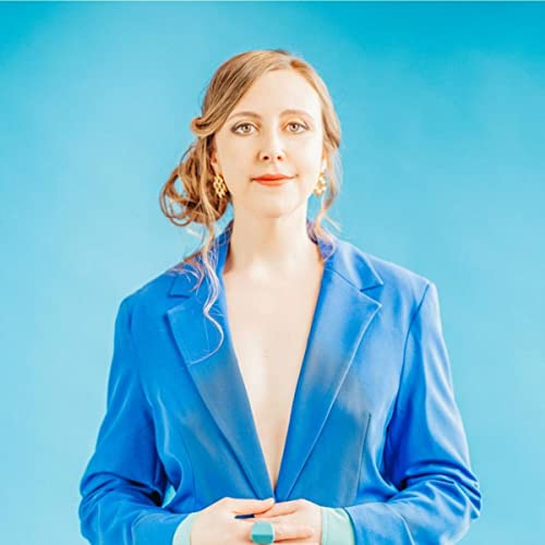 Siobhan Miller portrait, wearing a blue suit against a blue background.