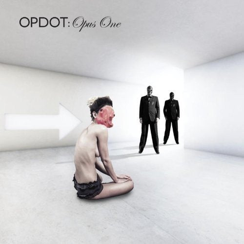 "Album cover with a man kneeling, masked, and two suited figures in a white room."